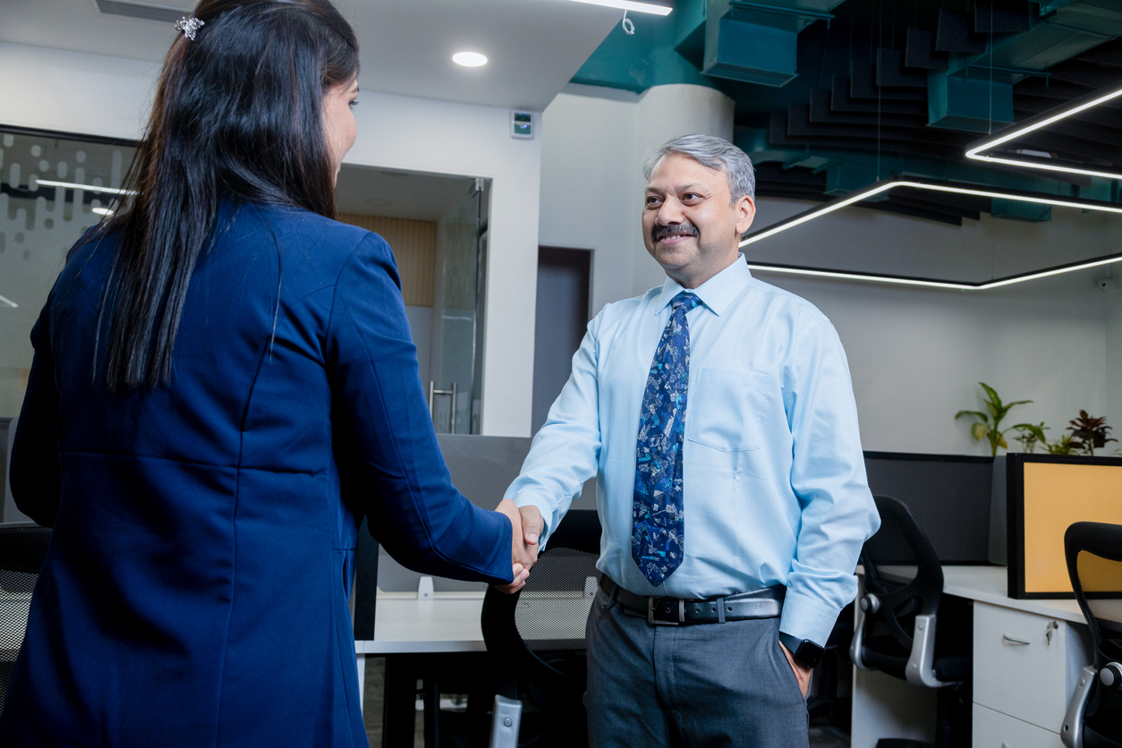 indian professional woman handshaking, greeting client in office. Executive making successful deal with partner at workplace. corporate and business concept.