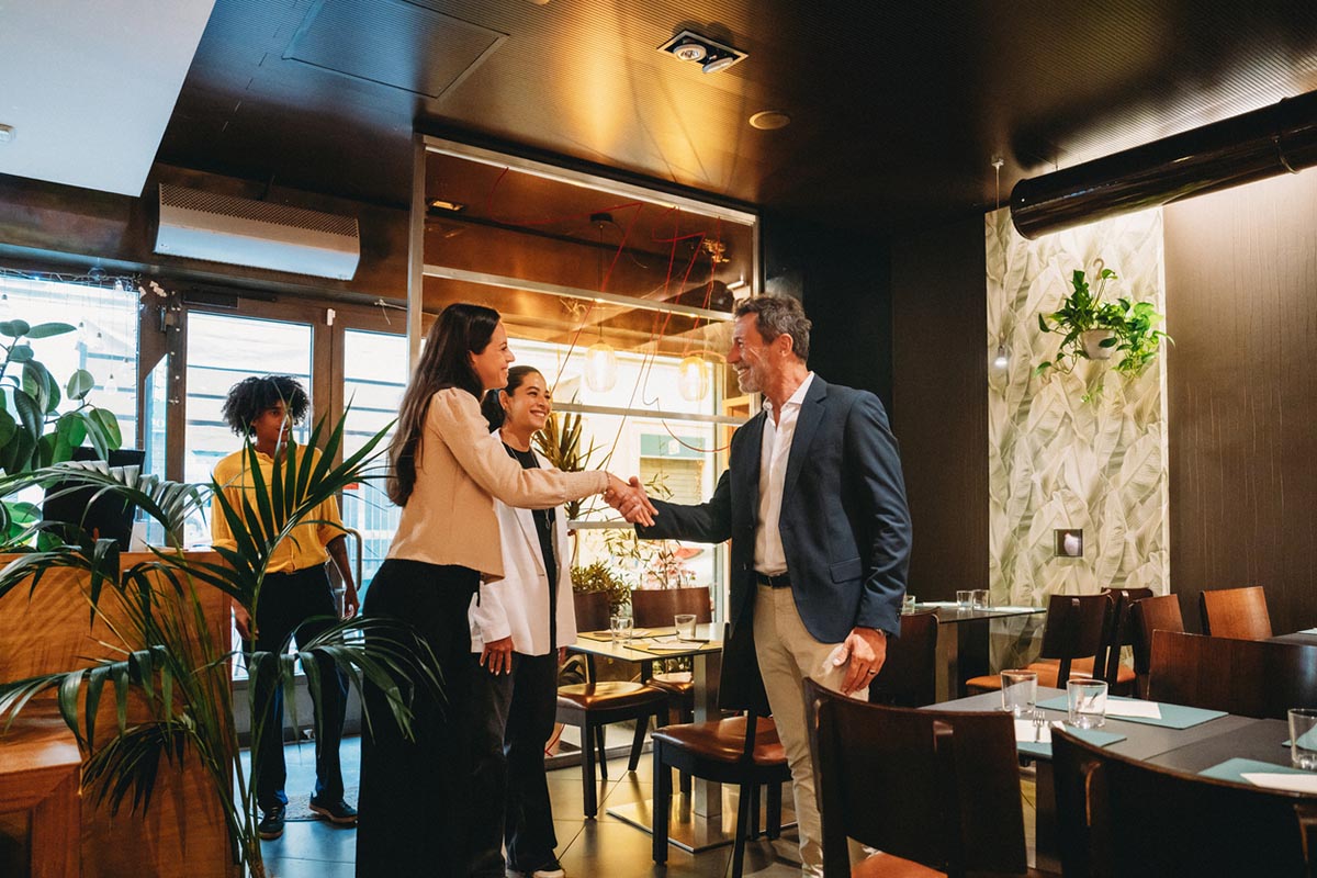 Businesspeople shaking hands at a restaurant meeting
